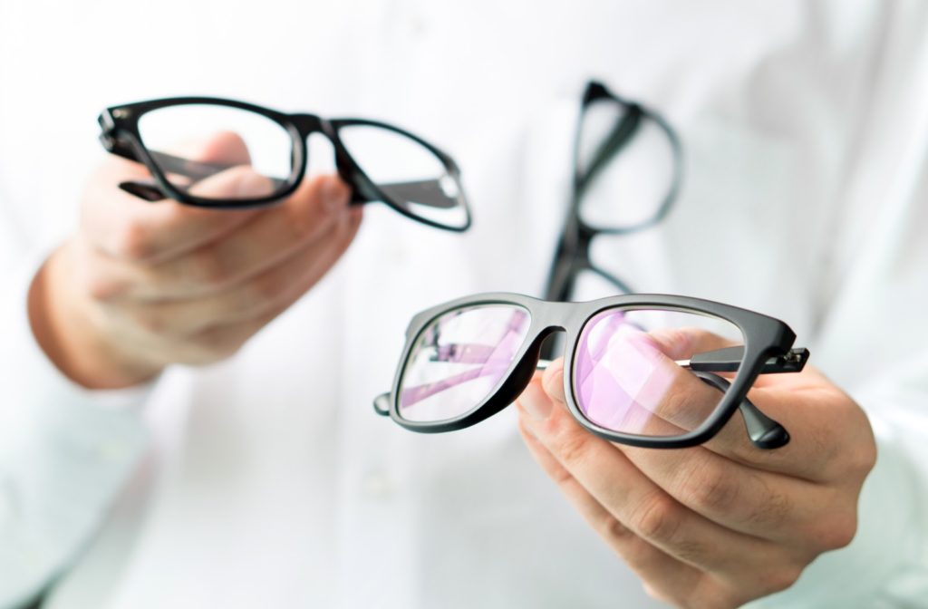 Optician comparing lenses and showing a customer different options in spectacles