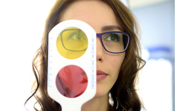 A woman completing a colour blindness test as part of the eye exam performed by her optometrist